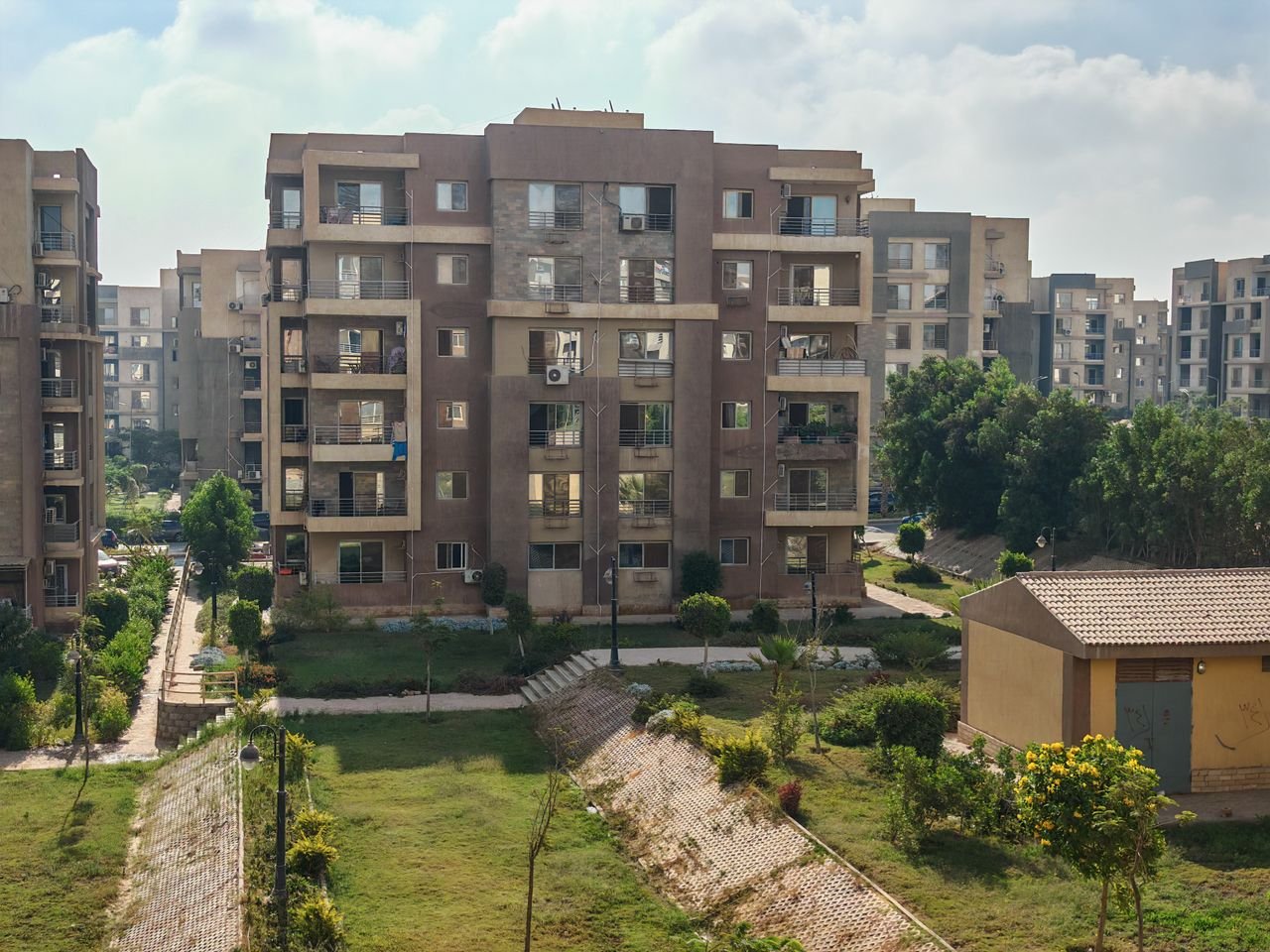 services-04 Aerial view of residential apartment buildings surrounded by greenery.